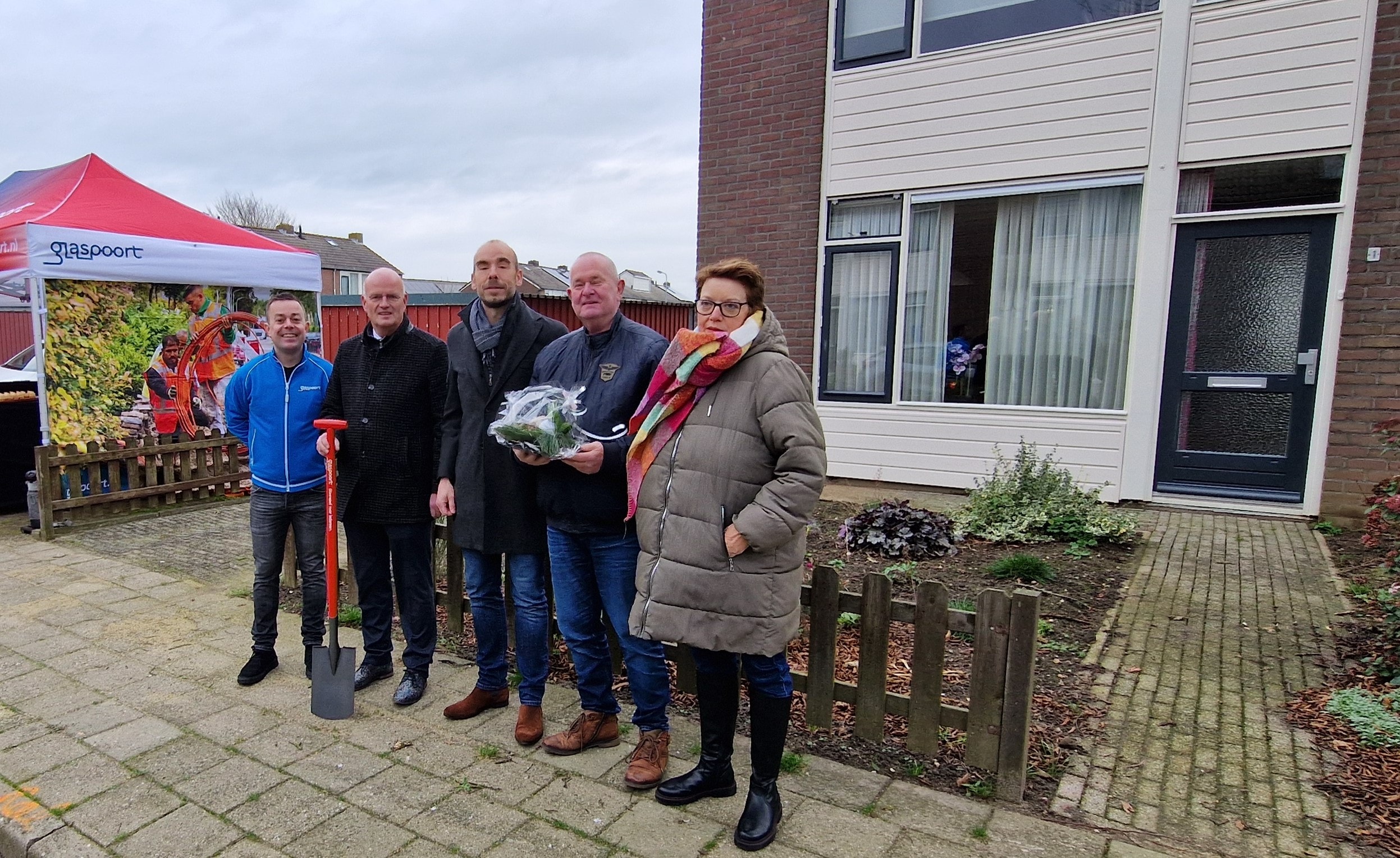 Aansluiting in Buren, mensen op een rij voor huis met bloemen